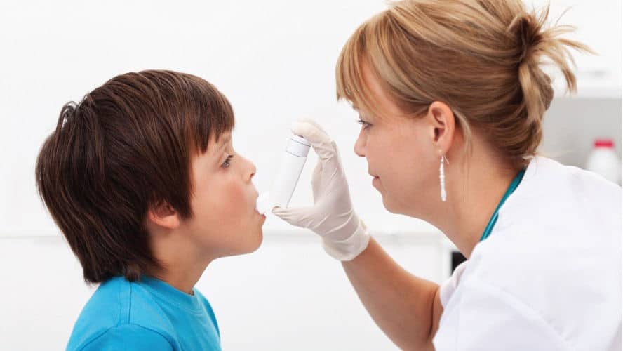 Doctora facilitando un inhalador a un niño
