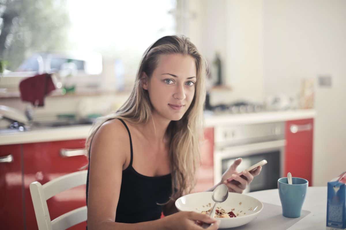 Gachas de avena: Guía nutricional, 3 beneficios y recetas Chica comiendo gachas de avena