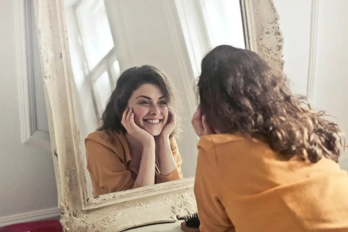 mujer segura y feliz mirándose al espejo