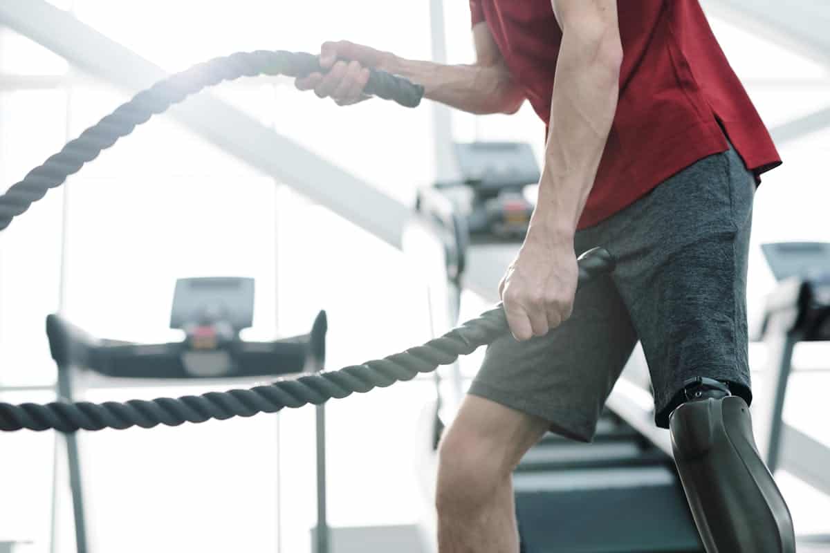 Deportista con battle rope a contraluz.