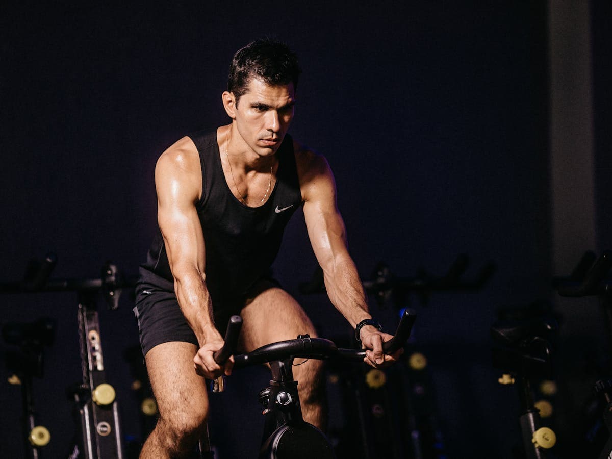 Qué es ciclo indoor: lo que necesitas saber Deportista entrenando en una bici.